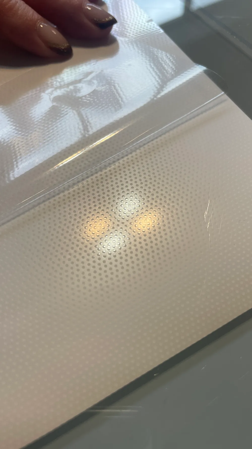 Close-up of LGP Sticker film with its dot raster and a partly peeled protective liner
